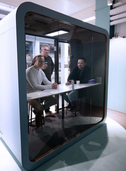 Three people smiling in a Framery Q meeting pod