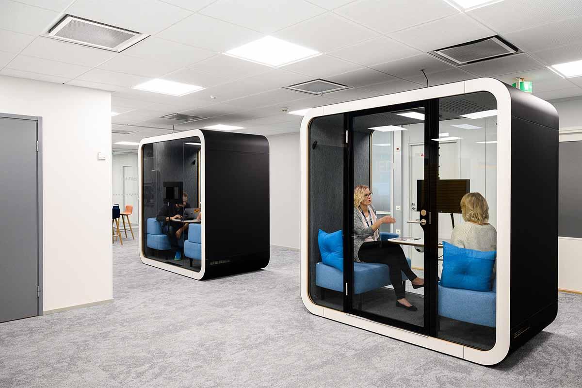 People using a Black Framery Q Meeting Pod as a focus room for working.