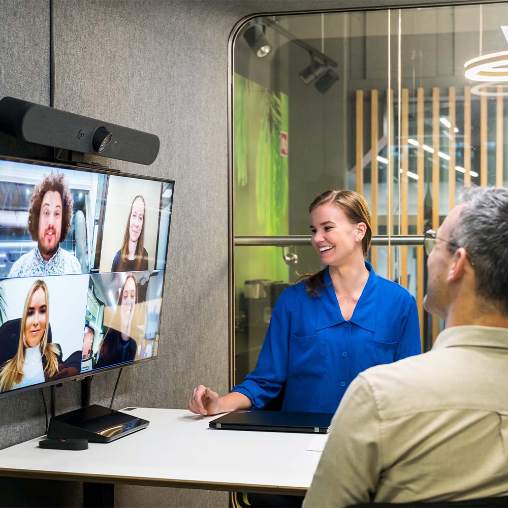 Multiple people having a video conferencing meet with colleagues working remotely. 