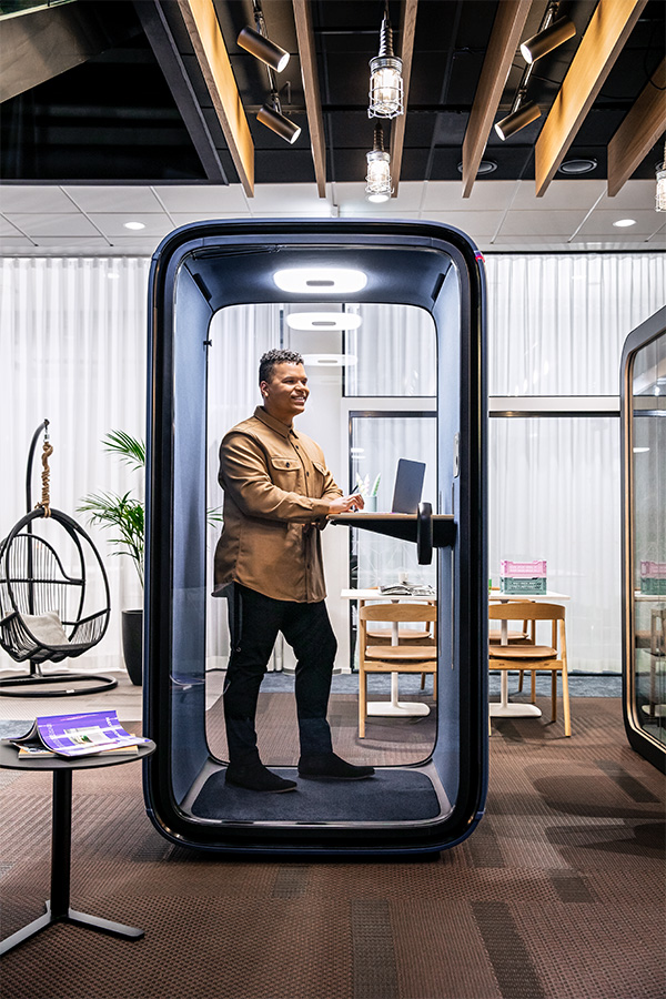 A person in a Framery One office pod in an open-plan office.