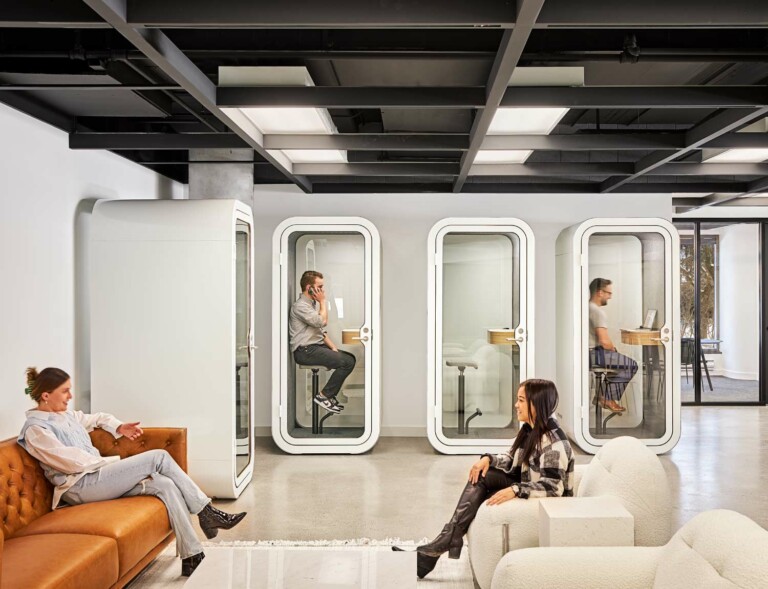 People having meeting in open-plan office while some are having a video conference in Framery O pods