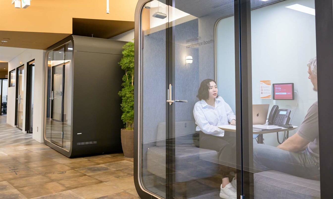 Framery Q being used as a privacy pod for private conversation in an open space.