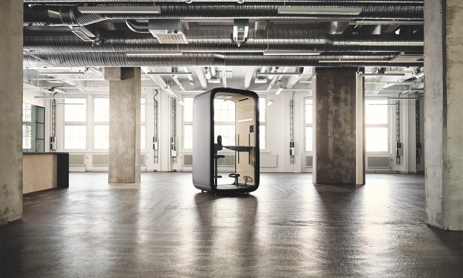 White Framery One soundproof office pod in a wide open space.